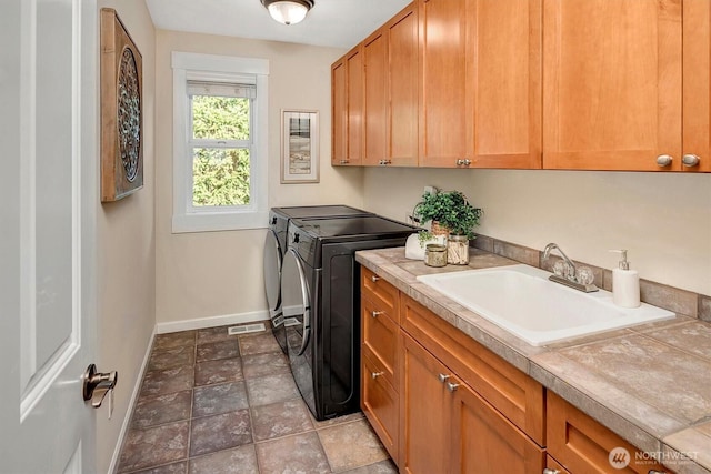 412 15th Ave, Kirkland, WA 98033 - laundry area featuring washing machine and clothes dryer, baseboards, cabinet space, and stone finish floors
