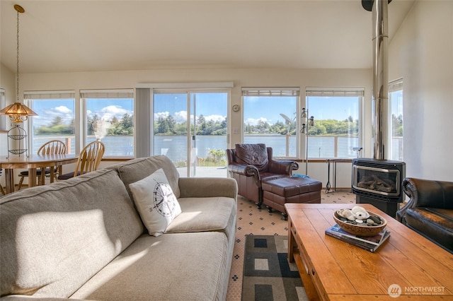 580 Mt Olympus Ave SE, Ocean Shores, WA 98569 - living area featuring light colored carpet, lofted ceiling, healthy amount of natural light, a wood stove, and a water view