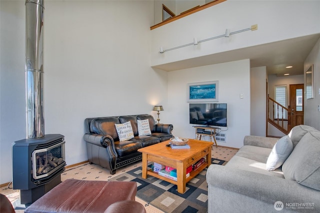 580 Mt Olympus Ave SE, Ocean Shores, WA 98569 - living room featuring a wood stove, stairway, and a high ceiling