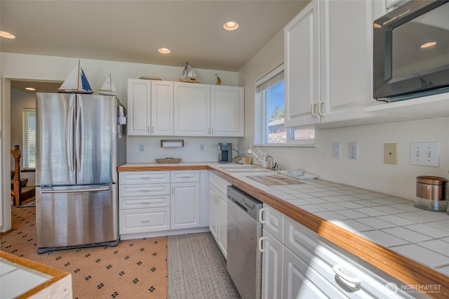580 Mt Olympus Ave SE, Ocean Shores, WA 98569 - kitchen with appliances with stainless steel finishes, a sink, white cabinets, tile countertops, and recessed lighting