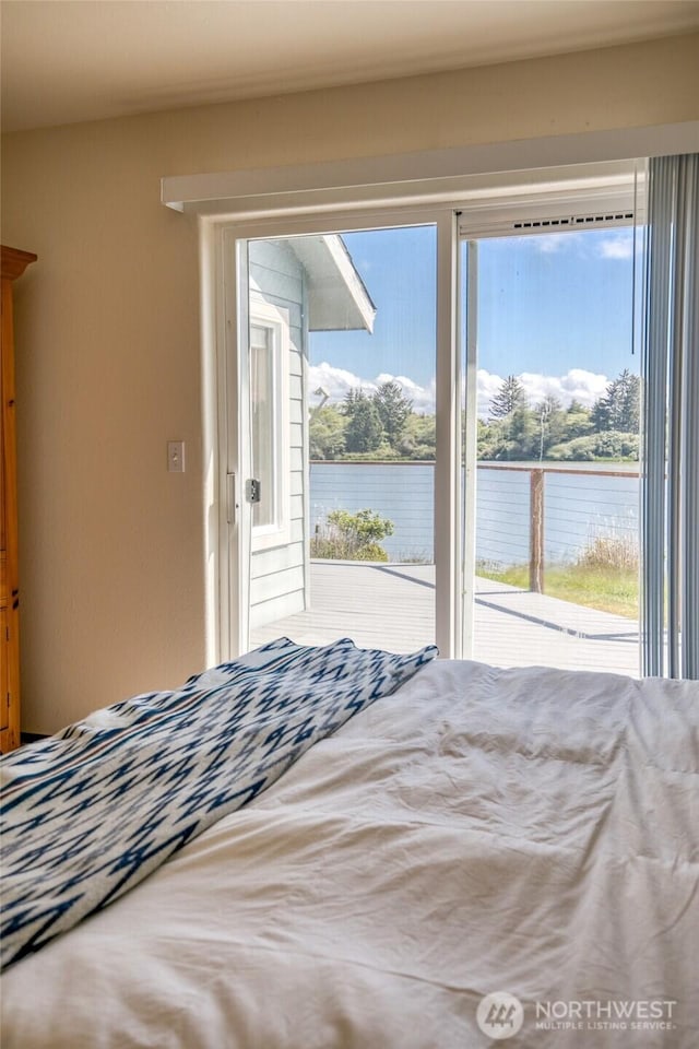 580 Mt Olympus Ave SE, Ocean Shores, WA 98569 - bedroom featuring access to exterior, a water view, and multiple windows