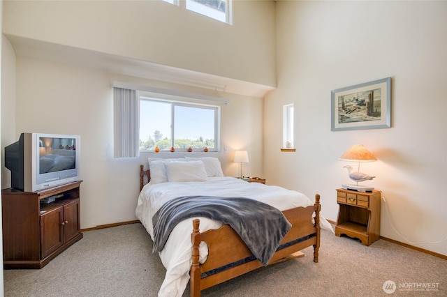 580 Mt Olympus Ave SE, Ocean Shores, WA 98569 - bedroom with light carpet, baseboards, and a towering ceiling