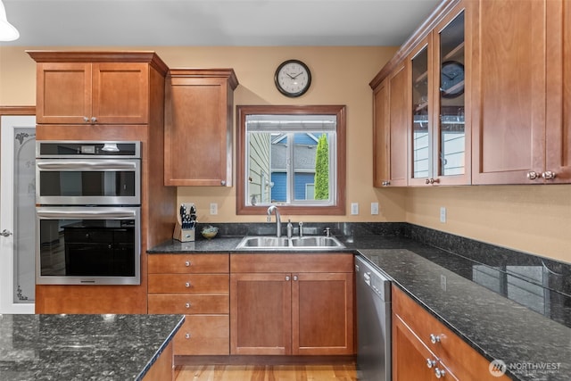 2616 171st Ave E, Lake Tapps, WA 98391 - kitchen with a sink, appliances with stainless steel finishes, brown cabinetry, glass insert cabinets, and dark stone counters
