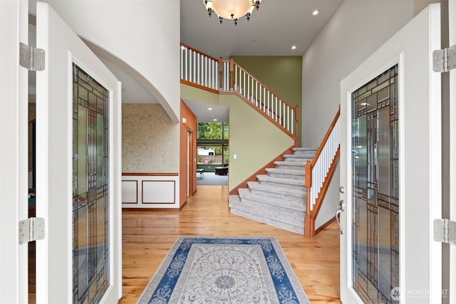 2616 171st Ave E, Lake Tapps, WA 98391 - foyer entrance featuring wood finished floors, arched walkways, stairway, a high ceiling, and wainscoting