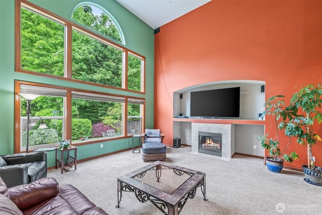 2616 171st Ave E, Lake Tapps, WA 98391 - living area featuring carpet flooring, a towering ceiling, a tiled fireplace, and baseboards