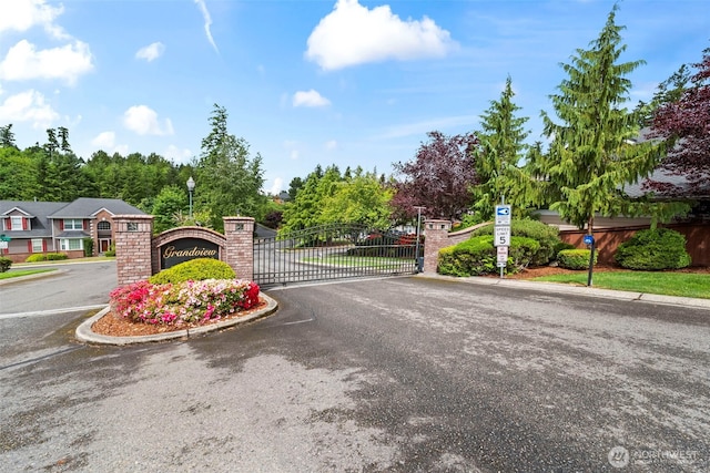2616 171st Ave E, Lake Tapps, WA 98391 - view of asphalt road featuring a gate, street lights, curbs, traffic signs, and a gated entry