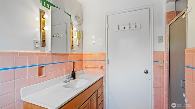 1109 University St, Walla Walla, WA 99362 - bathroom featuring tile walls, vanity, a stall shower, and a wainscoted wall
