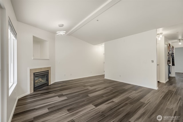 710 240th Way SE Unit J302, Sammamish, WA 98074 - unfurnished living room with dark wood-style flooring, a tiled fireplace, and baseboards