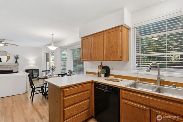 1826 168th Pl SE, Mill Creek, WA 98012 - kitchen featuring black dishwasher, a sink, a peninsula, light countertops, and light wood-style floors