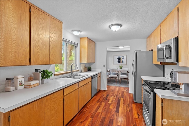 18802 10th Avenue Ct E, Tacoma, WA 98387 - kitchen featuring appliances with stainless steel finishes, a sink, dark wood-style flooring, light countertops, and a textured ceiling