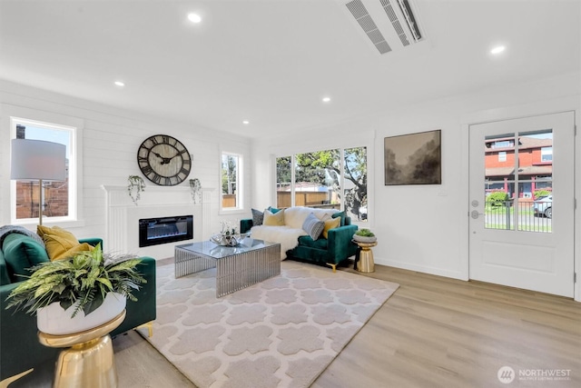 8042 19th Ave NW, Seattle, WA 98117 - living area with a glass covered fireplace, light wood-type flooring, and recessed lighting