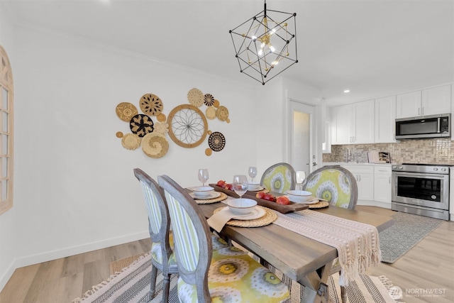 8042 19th Ave NW, Seattle, WA 98117 - dining space featuring a chandelier, light wood-type flooring, baseboards, recessed lighting, and crown molding