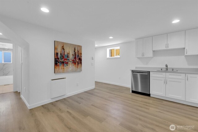 8042 19th Ave NW, Seattle, WA 98117 - kitchen featuring stainless steel dishwasher, a sink, white cabinetry, light wood finished floors, and light countertops