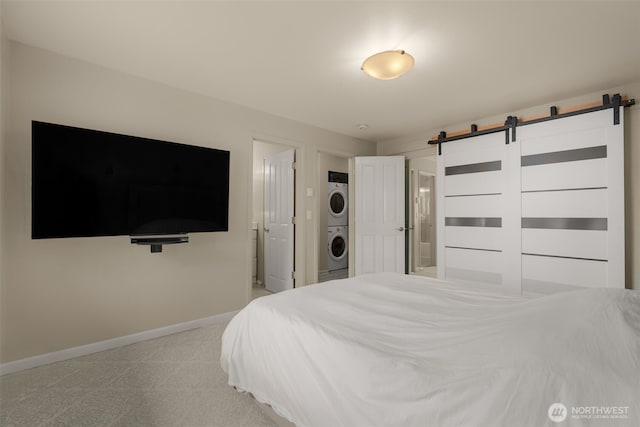 512 141st Ave SE Unit 55, Bellevue, WA 98007 - bedroom featuring stacked washer / dryer, a barn door, baseboards, and light carpet