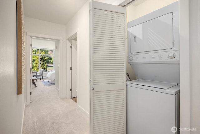 145 Ferncliff Ave NE Unit D338, Bainbridge Island, WA 98110 - washroom with stacked washer / drying machine, carpet floors, and baseboards