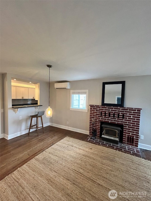 908 Washington Ave N, Long Beach, WA 98631 - unfurnished living room featuring a wall mounted air conditioner and dark wood-type flooring