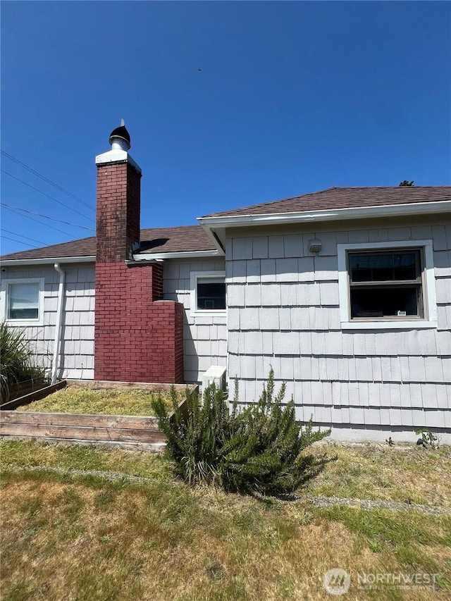 908 Washington Ave N, Long Beach, WA 98631 - view of property exterior with a chimney, roof with shingles, and a yard