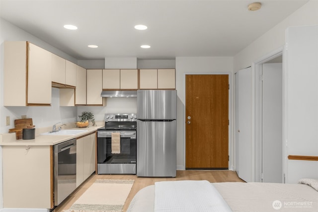 211 Summit Ave E Unit S218, Seattle, WA 98102 - kitchen with stainless steel appliances, under cabinet range hood, a sink, light countertops, and light wood-type flooring
