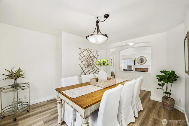 3534 SW Monroe St, Seattle, WA 98126 - dining room with light wood-style flooring, baseboards, and arched walkways