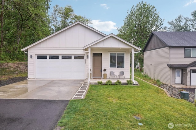 201 SE Alder St, Winlock, WA 98596 - view of front of house with board and batten siding, covered porch, driveway, an attached garage, and a front yard
