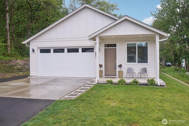 201 SE Alder St, Winlock, WA 98596 - view of front of house with driveway, board and batten siding, a front lawn, a garage, and covered porch