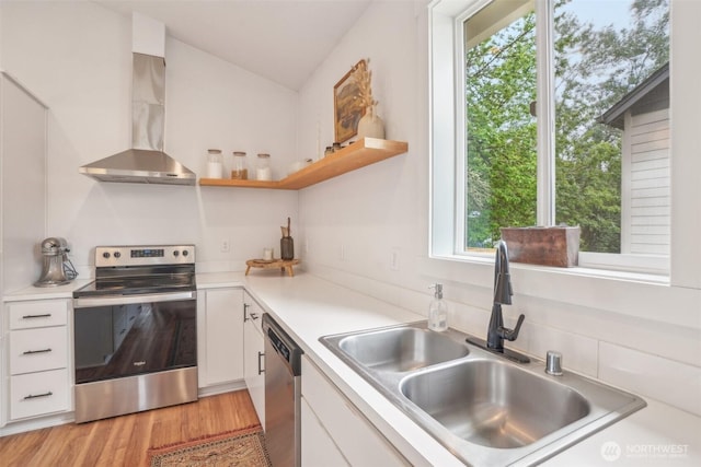 201 SE Alder St, Winlock, WA 98596 - kitchen with stainless steel appliances, wall chimney range hood, a sink, white cabinets, and light countertops