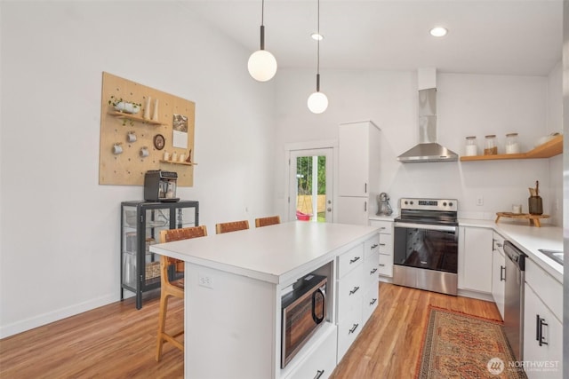 201 SE Alder St, Winlock, WA 98596 - kitchen featuring appliances with stainless steel finishes, wall chimney exhaust hood, open shelves, white cabinets, and a breakfast bar