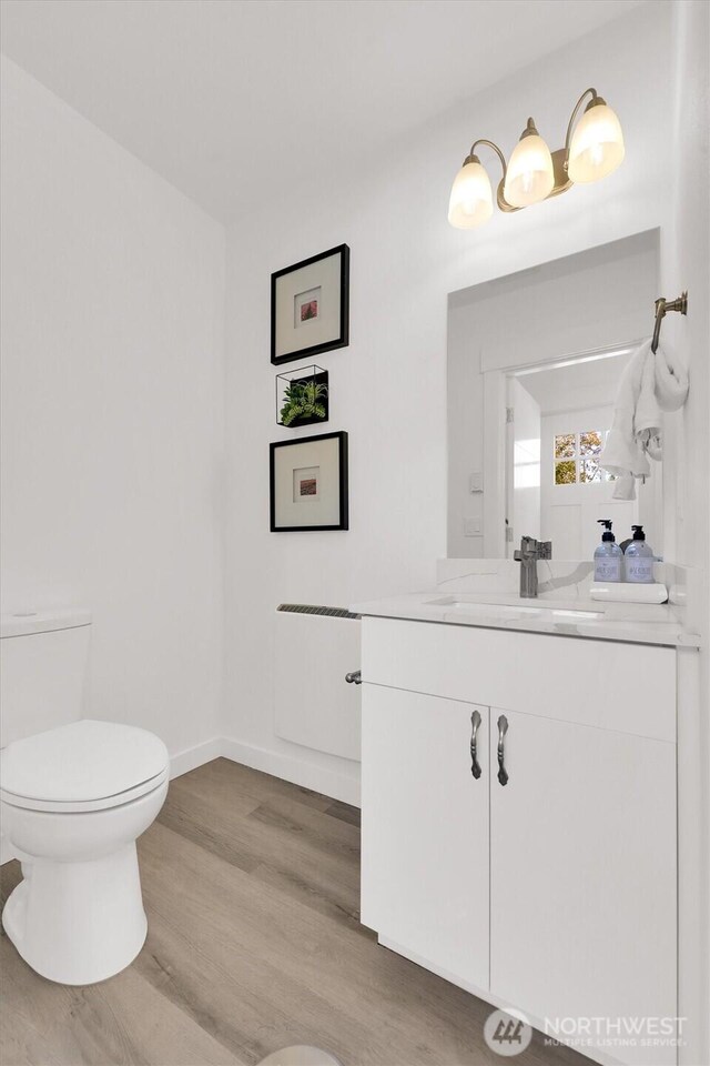 8040 19th Ave NW, Seattle, WA 98117 - bathroom with toilet, vanity, wood finished floors, and baseboards