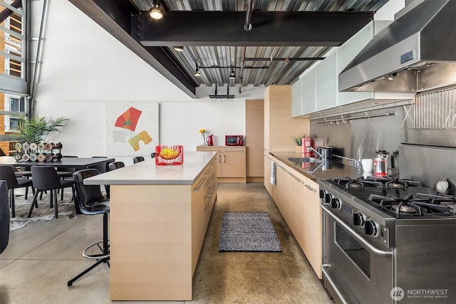 1310 E Union St Unit 401, Seattle, WA 98122 - kitchen with ventilation hood, gas stove, concrete flooring, a kitchen island, and light countertops