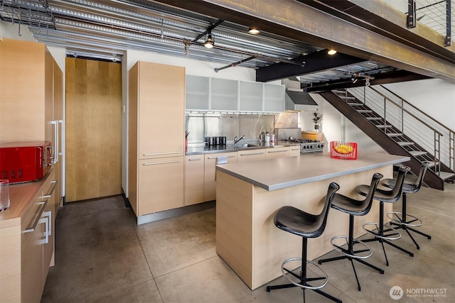 1310 E Union St Unit 401, Seattle, WA 98122 - kitchen with finished concrete floors, a kitchen breakfast bar, range, ventilation hood, and modern cabinets