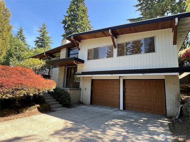 12509 SE 48th Pl, Bellevue, WA 98006 - view of front of house with brick siding, driveway, a garage, and a chimney