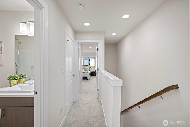 684 SW 100th St, Seattle, WA 98106 - corridor with a sink, an upstairs landing, light colored carpet, and recessed lighting