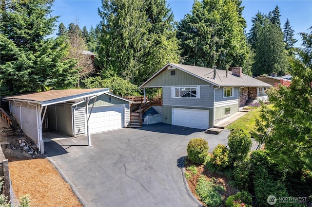 2207 Burcham St, Kelso, WA 98626 - view of front facade with stairway, a garage, a chimney, and driveway