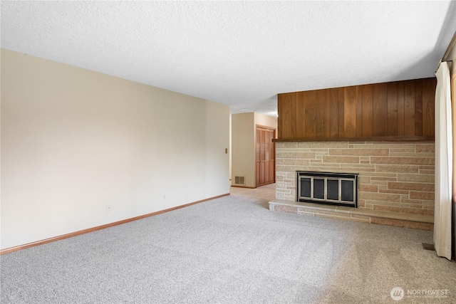 2207 Burcham St, Kelso, WA 98626 - unfurnished living room featuring carpet, baseboards, a stone fireplace, a textured ceiling, and wood walls