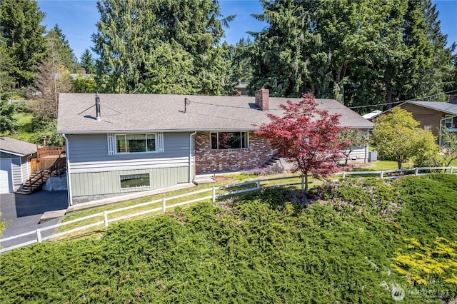 2207 Burcham St, Kelso, WA 98626 - ranch-style house featuring a fenced backyard, a chimney, roof with shingles, and view of wooded area