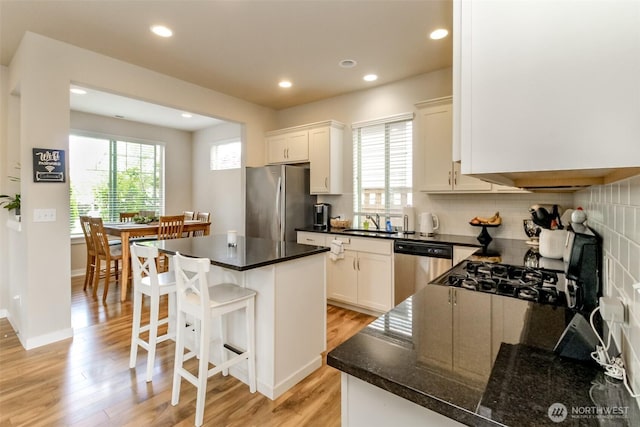 606 Sandalwood Dr SW, Olympia, WA 98502 - kitchen featuring stainless steel appliances, light wood-type flooring, a center island, tasteful backsplash, and recessed lighting
