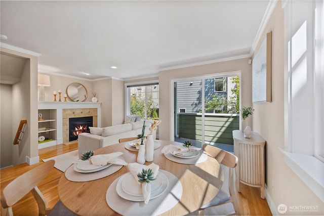 1738 NW 59th St Unit A, Seattle, WA 98107 - dining room featuring light wood-type flooring, crown molding, a tiled fireplace, baseboards, and recessed lighting