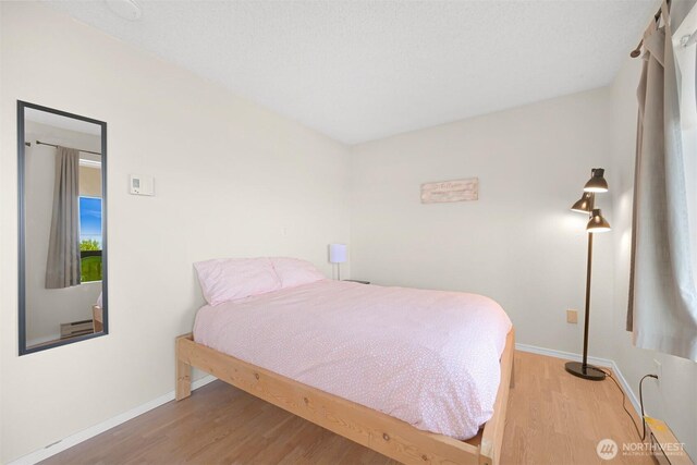 7530 Birch Bay Dr Unit 210, Blaine, WA 98230 - bedroom with wood finished floors, baseboards, and a baseboard radiator