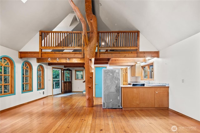 2548 S Camano Dr, Camano Island, WA 98282 - kitchen featuring high vaulted ceiling, light wood finished floors, fridge, and baseboards