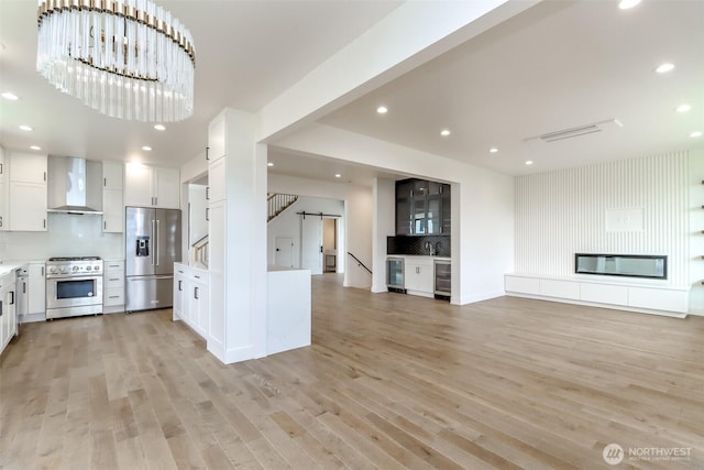 7253 S Taft St, Seattle, WA 98178 - kitchen featuring appliances with stainless steel finishes, wall chimney exhaust hood, open floor plan, backsplash, and recessed lighting
