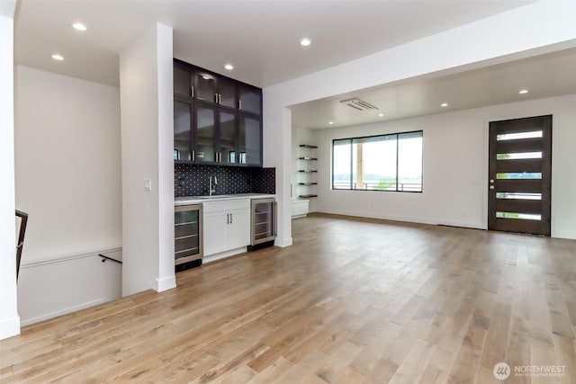 7253 S Taft St, Seattle, WA 98178 - unfurnished living room with beverage cooler, wet bar, light wood-type flooring, recessed lighting, and baseboards