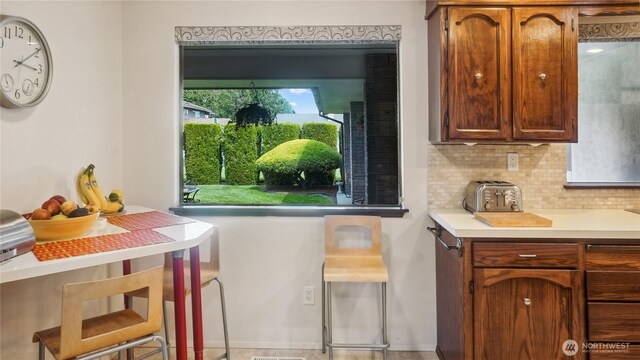 1525 E Catalpa St, Othello, WA 99344 - kitchen featuring backsplash, light countertops, and brown cabinetry