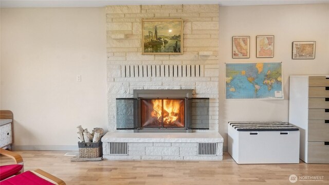 1525 E Catalpa St, Othello, WA 99344 - living room featuring wood finished floors, a lit fireplace, and baseboards