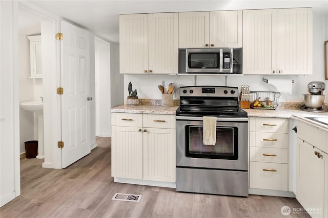 3854 Britton Rd Unit 1, Bellingham, WA 98226 - kitchen with stainless steel appliances, light wood-style flooring, light stone countertops, and baseboards