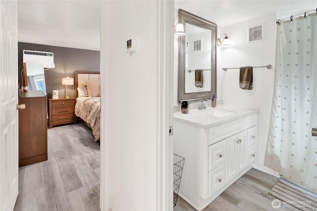 3854 Britton Rd Unit 1, Bellingham, WA 98226 - ensuite bathroom with wood finished floors, a wall mounted AC, vanity, and a shower with curtain