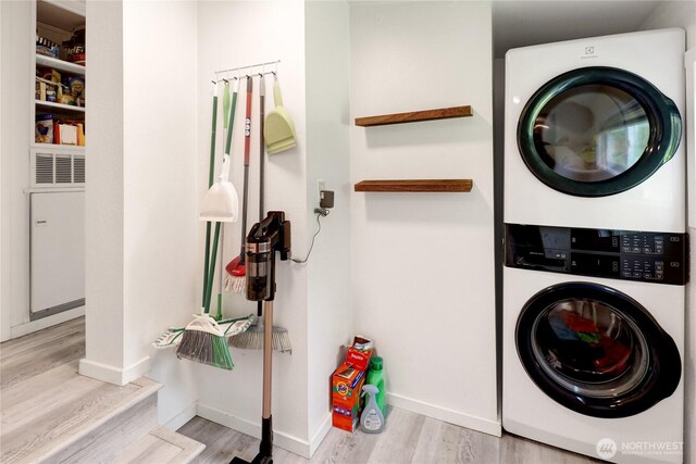 3854 Britton Rd Unit 1, Bellingham, WA 98226 - washroom featuring stacked washer and clothes dryer, wood finished floors, baseboards, and a heating unit