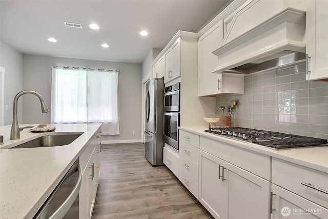 3007 Fiddleback St NE, Lacey, WA 98516 - kitchen featuring premium range hood, stainless steel appliances, recessed lighting, white cabinets, and tasteful backsplash