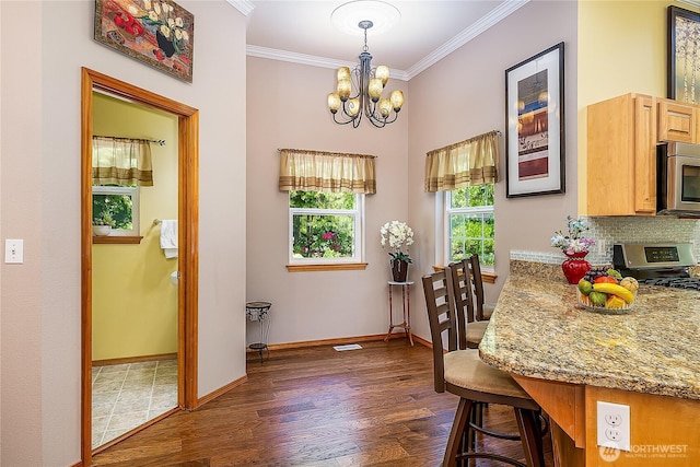 6841 NW Ranger Way, Silverdale, WA 98383 - dining space with a chandelier, dark wood-type flooring, crown molding, and baseboards