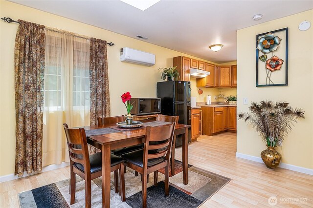 6841 NW Ranger Way, Silverdale, WA 98383 - dining area featuring a wall mounted air conditioner, light wood-style flooring, and baseboards