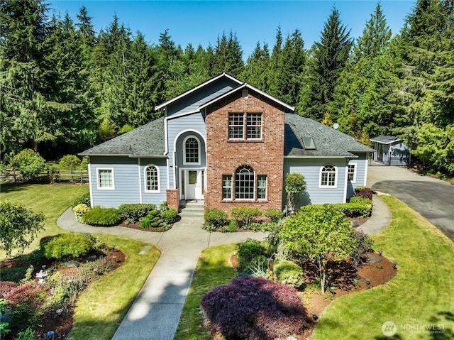 6841 NW Ranger Way, Silverdale, WA 98383 - traditional home with a shingled roof, brick siding, a forest view, and an outdoor structure